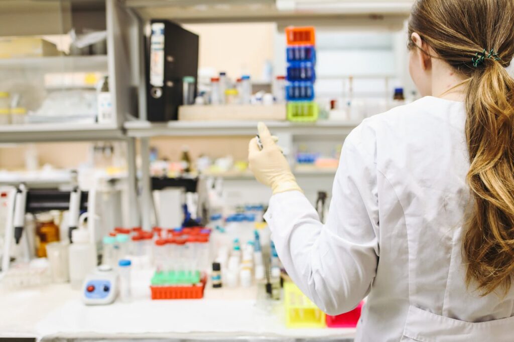 A woman in a laboratory setting conducting scientific research with test tubes.